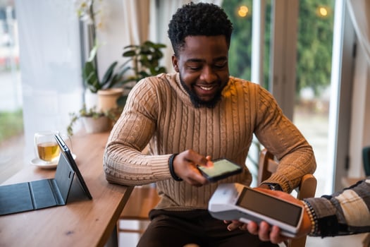 Man paying with smartphone at bar photo