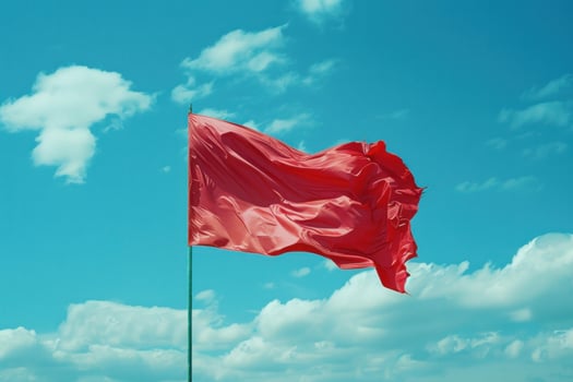 Red flag waving in the wind on cloudy sky photo