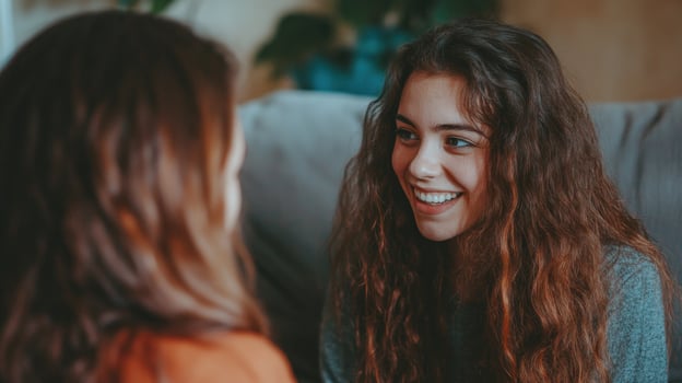 Two young women share a joyful moment, exchanging smiles and laughter in a warm and inviting space photo