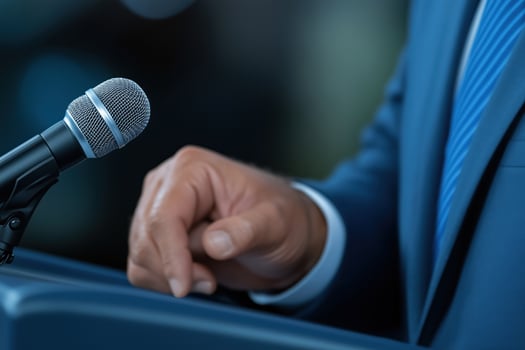 close-up of a politician's hand giving a speech from a podium, photo