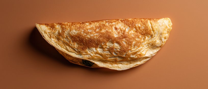 Delicious folded omelet on a brown background photo