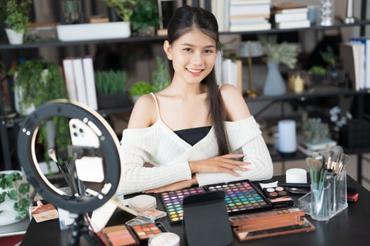 woman beauty influencer makeup artist vlogger live streaming makeup tutorial on social media. photo
