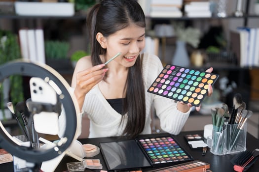 a woman is holding a makeup palette and looking at it. photo