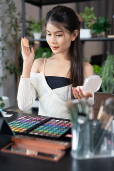 beauty and makeup concept, asian woman applying makeup on her face. photo