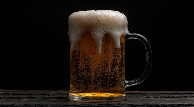 Close up of a beer mug with a thick head of foam photo
