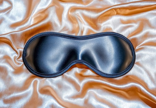 Black silk sleep mask on gold silk fabric photo