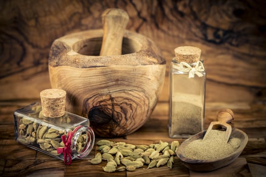 two bottles with green cardamom Elettaria cardamomum on olivewood photo