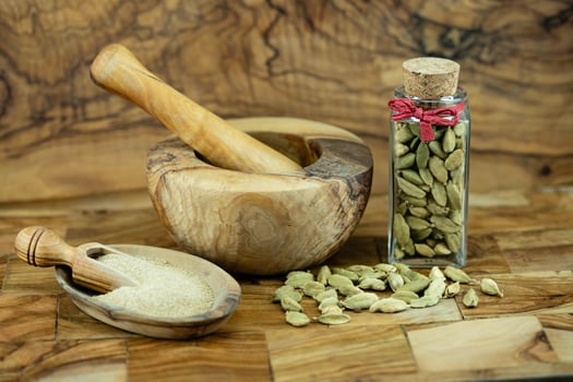 green cardamom capsules on olive wood photo