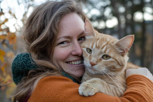 A woman is hugging an orange cat photo