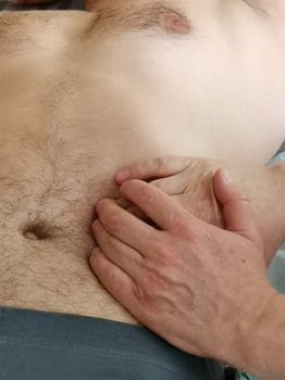 A real osteopath work with a man's abdomen. . Visceral massage to remove clamps and tension from the sphincters in the gastrointestinal tract. Visceral osteopathy photo