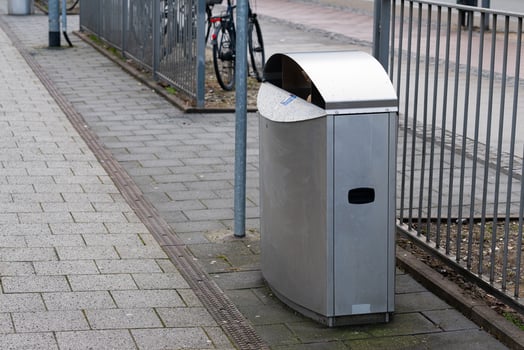 Modern trash bin on urban street with bicycles nearby photo