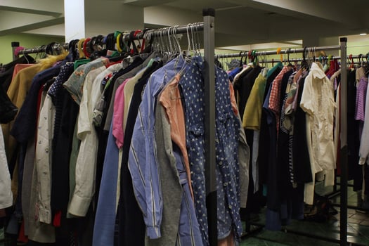 Close-up of rack of colorful clothes hanging in row with variety of textures and styles. Fashion and personal style, diversity of clothing and individual expression. Retail or wardrobe management photo