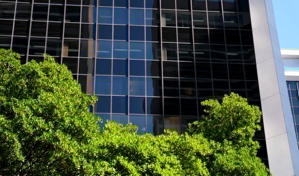 Eco-friendly building in the modern city. Sustainable glass office building with trees for reducing heat and carbon dioxide. Office building with green environment. Corporate building reduce photo
