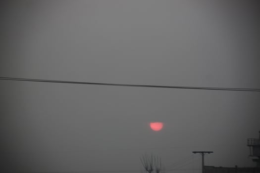 A red sun is seen in the sky photo