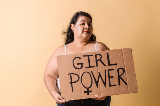 portrait of plus size latin american woman holding a banner. girl power concept. photo
