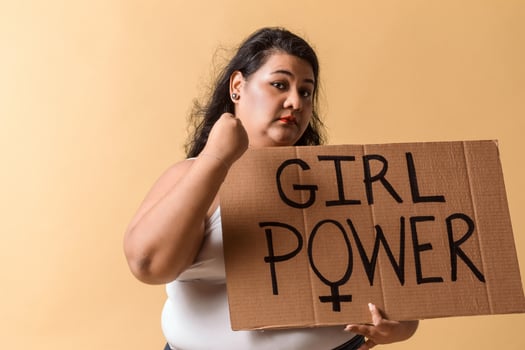Oversized woman holding girl power banner over and showing her fist. photo
