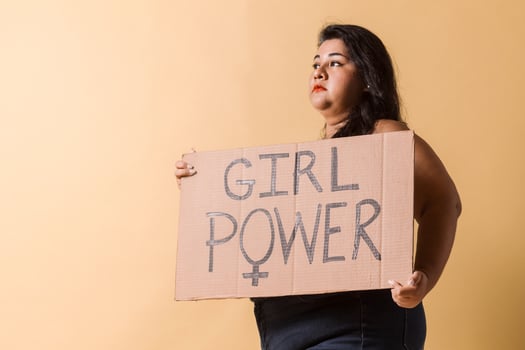 plus size woman looking away with girl power banner over. photo