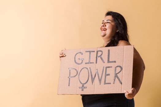 cheerful plus size latin american woman looking away with girl power banner over. photo