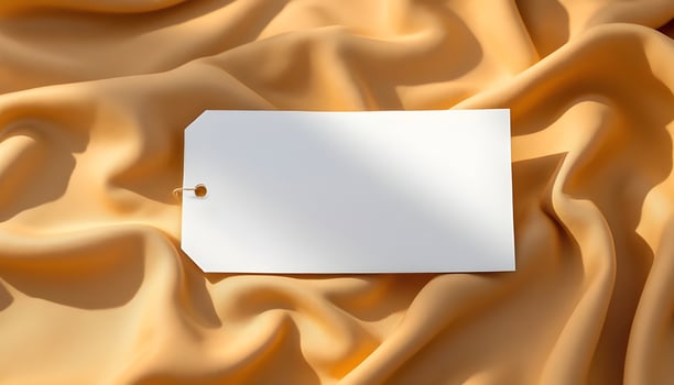 Blank White Tag on Soft Gold Silk Fabric photo