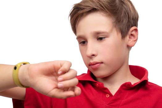 A teenage boy watches the time on his watch in close-up. photo