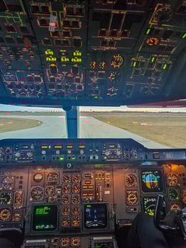 Illuminated cockpit view of an aircraft ready for takeoff at sunrise. High quality photo