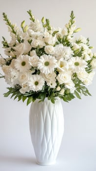 A white vase filled with white flowers photo