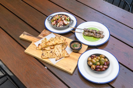 A wooden table topped with plates of food photo