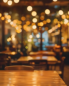 Wooden Table in Blurred Restaurant Interior with String Lights photo