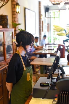 Young Vietnamese waitress serving a customer at the checkout in cafe. photo