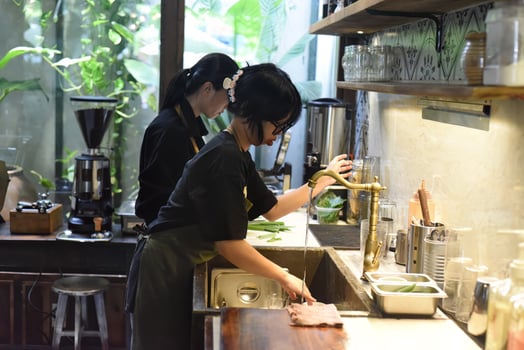 Vietnamese waitress gets ready an order in a coffee shop photo