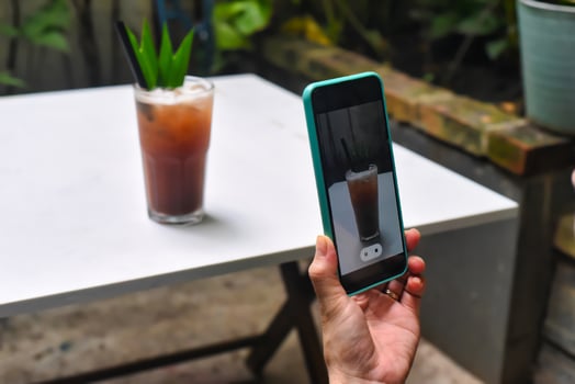 A woman taking picture of plum tea for advertisement photo