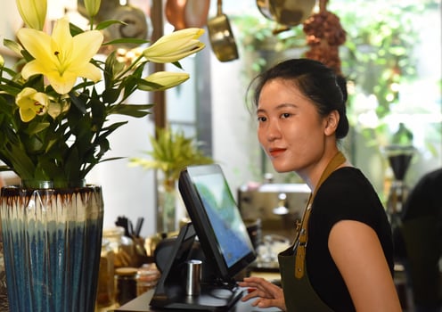 Young Vietnamese waitress working with check out machine photo