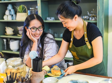 Vietnamese waitress serving a customer ice cream with waffle in Vietnamese coffee shop photo
