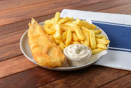 Fish and chips on a plate with a napkin photo