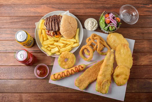 A plate of food including fries, onion rings, and a hamburger photo
