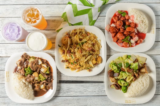 Four plates of food with drinks on a wooden table photo