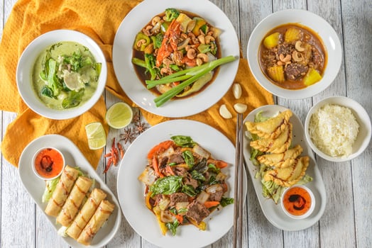 Various plates of food on a table with a bowl of soup photo