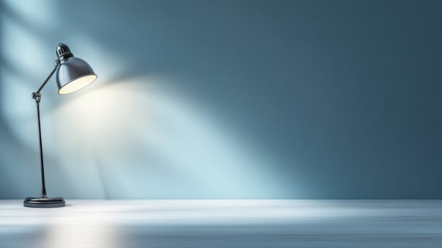 desk lamp casting soft glow on simple workspace with blue wall photo