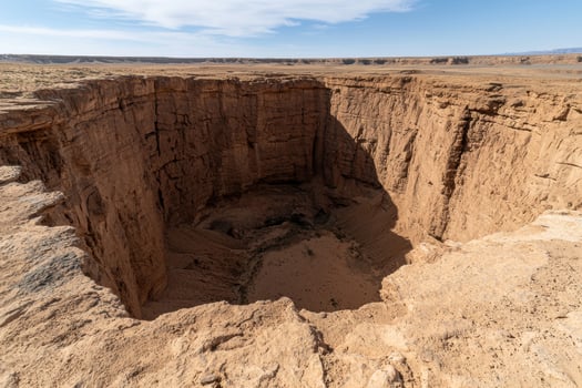Aerial view of a large crater in a desert landscape photo