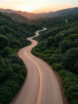 Serpentine road through lush green hills at sunset photo