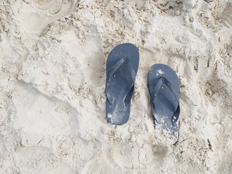 A pair of blue flip flops on a sandy beach photo