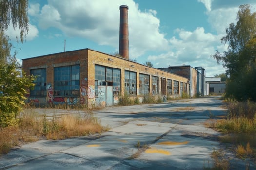 Abandoned industrial building with graffiti and broken windows showing urban decay photo