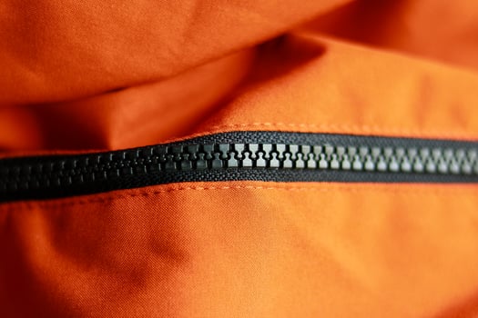 Zipper on the orange jacket. Close up view of zipper. photo