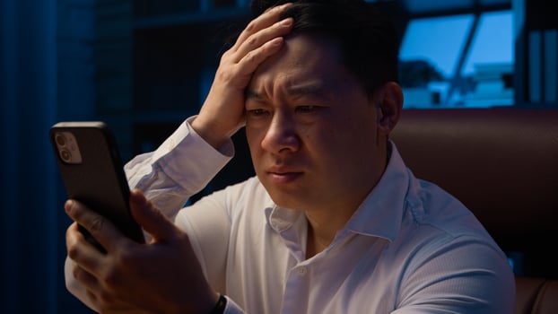 Asian adult man at night evening at home office lost failure with mobile phone sad unhappy Chinese male with smartphone lose bad news frustrated upset Korean middle-aged businessman cellphone problem photo