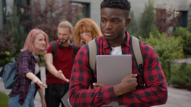 Group of angry students teenagers multiracial classmates laughing humiliate bully mockery at college university outdoors discriminate mock African American sad upset man student stressed guy problem photo