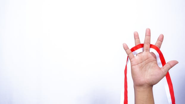 Hand with Red and White Ribbons on White Background photo