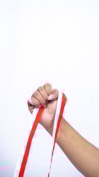 Clenched Fist with Red and White Ribbons on White Background photo