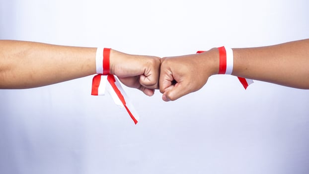 Hands Wearing Red and White Ribbons Doing Clenched High Five on White Background photo