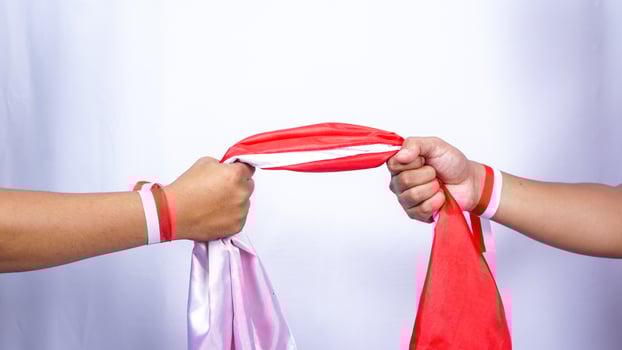 Two Hands with Red and White Ribbons Holding Indonesia Flag Together on White Background photo