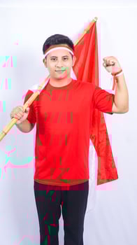 Indonesian Man with Red and White Attribute and Flag on White Background photo